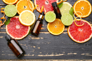 Cold-pressed citrus essential oils with fresh fruits on a dark wooden background
