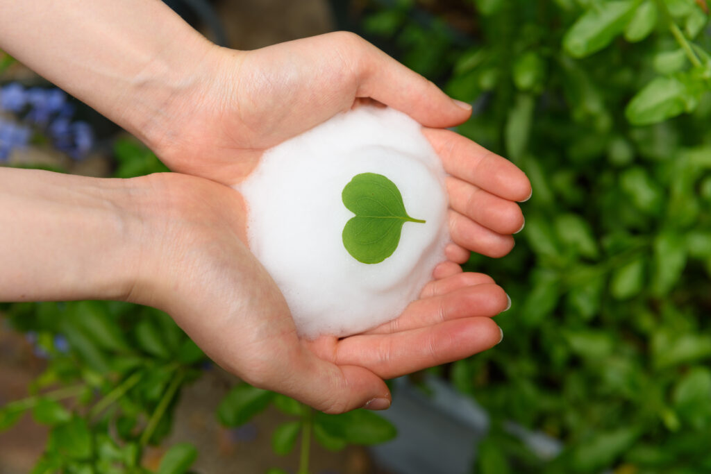 Natural surfactant foam in a laboratory glass beaker, used in skincare and haircare formulations.